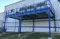 View of an exterior blue equipment platform that adjoins a building, engineered by Panel Built to support heavy machinery