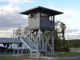 Exterior view of grey 8' x 10' x 12' high tower with guard house on top engineered by Panel Built to enhance perimeter security