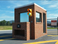 A compact prefabricated security booth with large windows and an enclosed workspace for monitoring vehicles and visitors at a school entrance.