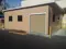 Exterior view of a large outdoor equipment building with a roll door to protect equipment from harsh weather