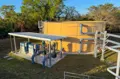 View of a custom 29' x 12' freestanding steel canopy designed around existing water treatment equipment to provide overhead weather protection while maintaining open access.